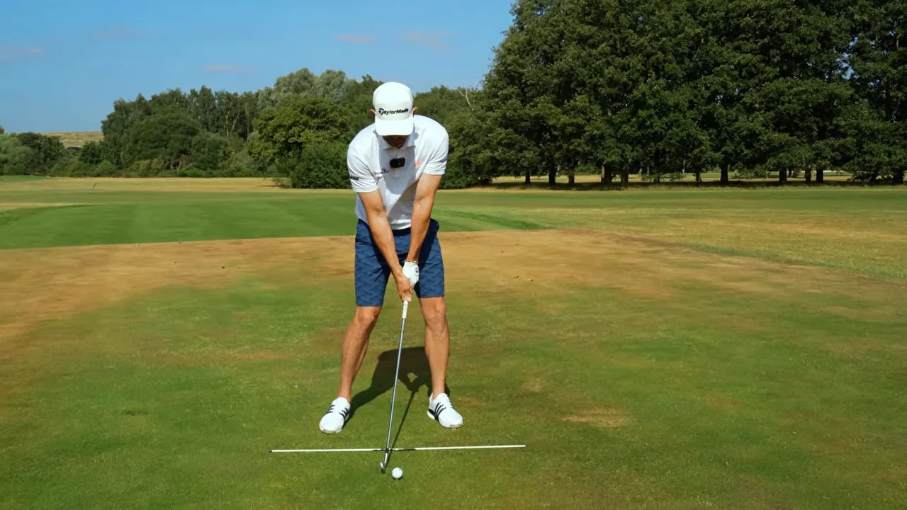 Golfer at delivery position with a green check mark beside the clubface