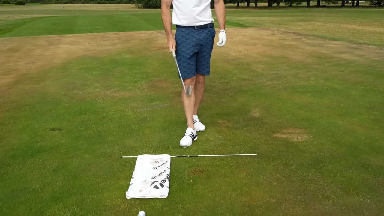 Towel behind the ball remains undisturbed beside alignment sticks after the strike