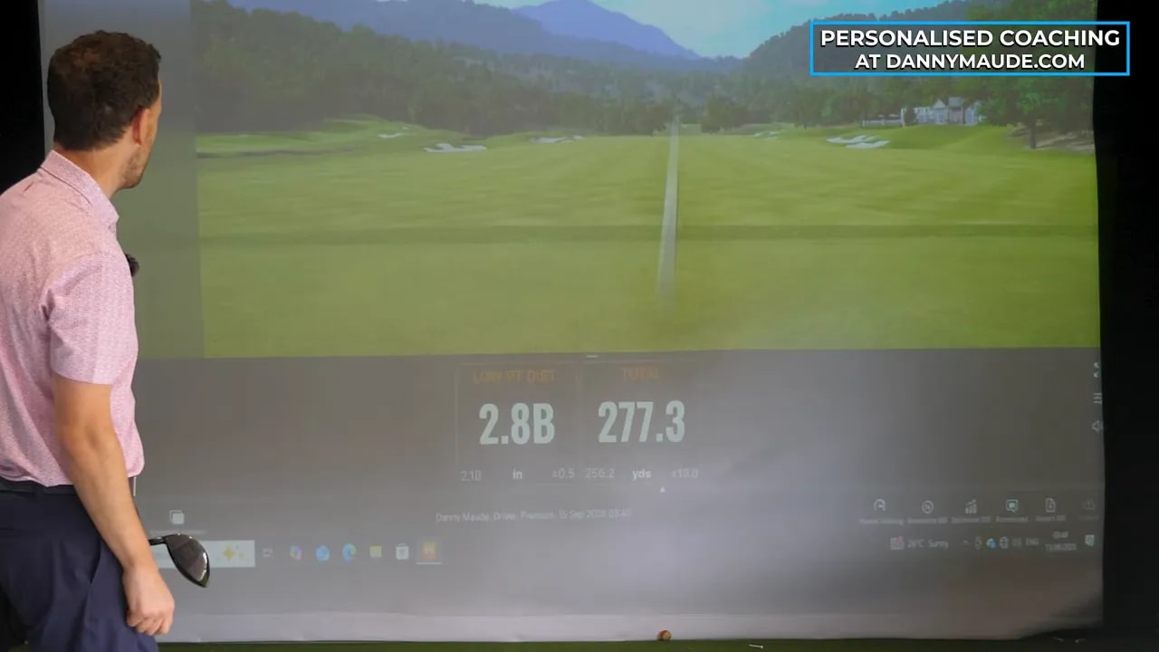 Golf simulator screen displaying a driver shot tracer and distance reading of 277.3